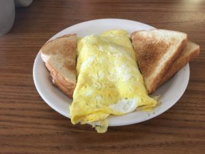 A large omelet in between pieces of toast being served at Village Kitchen in Angola, IN