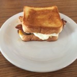 A breakfast sandwich with toast, bacon, sausage, egg, and cheese at Village Kitchen in Angola, IN