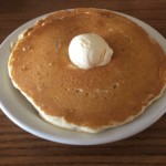A large pancake with a dollop of butter on a white plate at Village Kitchen in Angola, IN