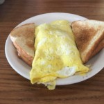 A large omelet in between pieces of toast being served at Village Kitchen in Angola, IN