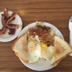 A breakfast platter with eggs, toast, bacon, and hash browns at Village Kitchen in Angola, IN
